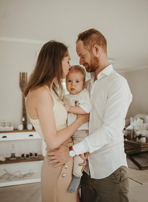 Eltern schmusen mit ihr kind pose im Familienshooting fotografiert vom Familien Fotograf