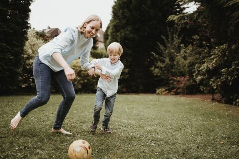 mutter spiel mit ihren Kinder Fussball im garten in kelheim im rahmen eines familienshooting