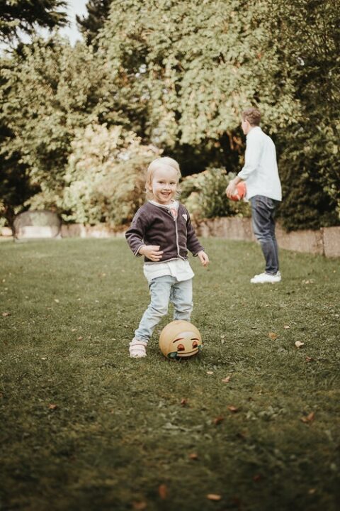 Glückliches kind bei spielen im garten beim spielen aufgenommen vom kinderfotograf