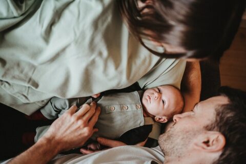 neugeborenes im armen seiner eltern beim neugeborenen homestory