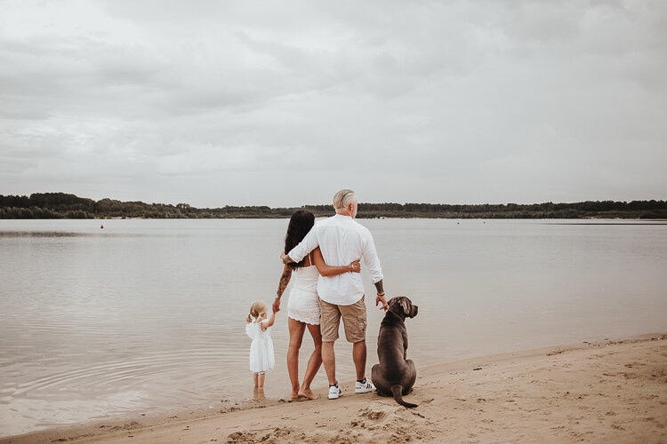 Familienfoto man sieht die Eltern mit ihre kleine Tochter und hund